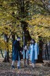 © Doralin - Pregnant family walking in autumn forest exploring nature
