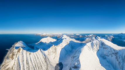 Wall Mural - Flight over the mountains. Scandinavia. Aerial view on the Lofoten Islands, Norway. Wide panoramic view of the north. Natural winter landscape from air. Photo for postcards, backgrounds, wallpapers.