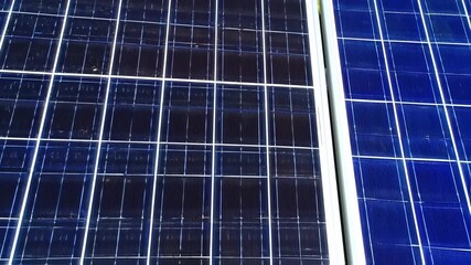 Close-up of two solar panels, grid patterns visible, with dark & light blue hues