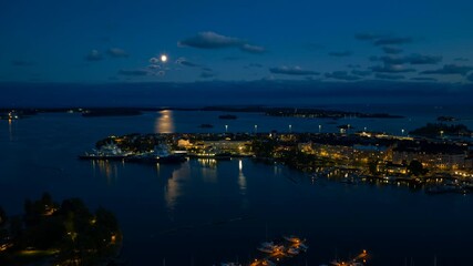 Wall Mural - Aerial hyperlapse over Pohjoisranta, toward the moon above the sea of Helsinki