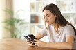 © PheelingsMedia - Woman checking two phones installing new one