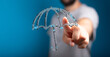 © vegefox.com - Concept image of a person's hand interacting with a digital umbrella representing protection, security, and insurance. Modern digital design wit