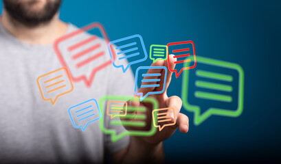 A man touches digital speech bubble icons. Concept of communication, connection, social media, and digital interaction.