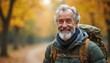 © Pete - Smiling senior man with backpack walks on autumn forest path. Elderly person enjoys nature, travels in woods, healthy lifestyle and adventure.