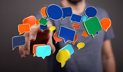 Close-up of a man's hand interacting with digital speech bubbles, symbolizing communication and technology integration.