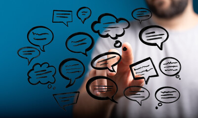 A man interacts with digitally drawn speech bubbles representing ideas, communication, and modern networking. Communication in the digital age.