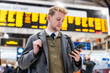 © william87 - Young man commuting, checking phone at train station