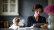 © Chandlerlikes - A multitasking mother working on her tablet while her child quietly plays nearby, illustrating real work-life harmony.