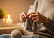 © rfassets - Hands Knitting in Cozy Candlelit Home Setting