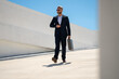 © Volodymyr - Business outdoor portrait. Business man walking outdoors. Corporate leader on move. Man in suit with briefcase. Business man going to work. Businessman with briefcase. Business man go to office.