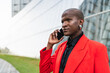 © ADDICTIVE STOCK - Young man in red jacket using smartphone outdoors