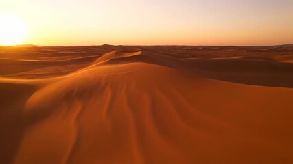 Wall Mural - Aerial gliding shot over undulating desert sand dunes with subtle wind creating natural swirling patterns at golden hour undulating desert sand, desert, background