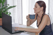 © shustrilka - Young woman, dark hair working remotely from home, online meeting international partner via video call