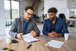 © Miljan Živković - Businessmen discussing contract terms during an office meeting