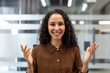 © Liubomir - Young woman smiling at camera, having engaging conversation during online video conference, expressing happiness and optimism in modern corporate environment