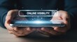 © Vodkaz - Hands holding a smartphone displaying online visibility search concept.