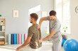 © Studio Romantic - Male physiotherapist consulting patient In rehabilitation center. Physical therapist evaluating recovery progress from major traumatic injury. Post-trauma physical rehabilitation clinic concept.