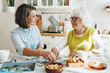 © shurkin_son - Senior lady in glasses solving puzzle with assistance of her caregiver sitting at kitchen table, having warm friendly relationships during her alzheimer rehabilitation therapy at nursing home