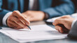 © valeo5 - businessmen in suits negotiating or finalizing a deal, with a pen poised over a contract or important document. Represents finance, law, agreement, consultation, partnership, corporate business