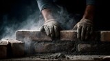 A construction worker s gloved hands carefully place bricks with cement and dust swirling in the air highlighting the intricate process of building a