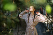 © Westend61 - Smiling woman standing with eyes closed near trees