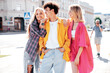 © halayalex - Group of young three stylish friends posing in the street. Fashion man and two cute female dressed in casual summer clothes. Smiling models having fun. Cheerful women and guy outdoors