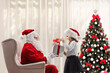 © Ljupco Smokovski - Excited kid opening a gift box in front of santa at home