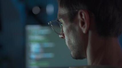 Nighttime programmer working with focus in his tech workspace.