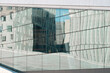 © yaqui_villegas - Modern glass facade reflecting curved surfaces and soft light across urban architecture landscape in Oslo business district