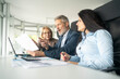 © Nenad - Business professionals having meeting in office discussing company goals and planning project with laptop