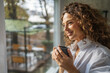 © Miljan Živković - woman enjoying coffee looking out window