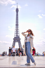  Fashionable woman traveler standing in front of Eiffel Tower in Paris