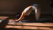 © Emilio - Woman in extended puppy pose on yoga mat. Warm sunlight and shadows create serene atmosphere. Balance, peace and focus in minimalist home interior