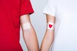 © mark - Blood Donation: Two Arms with Bandages After Giving Blood.