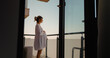 © RecCameraStock - Future mother in white dress admiring the sky and city from the balcony large view. Pregnant having healthy lifestyle staying in the sun and breathing fresh air while on balcony.