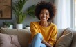 © wu - people, race, ethnicity and portrait concept - happy african american young woman sitting on sofa at home. High quality