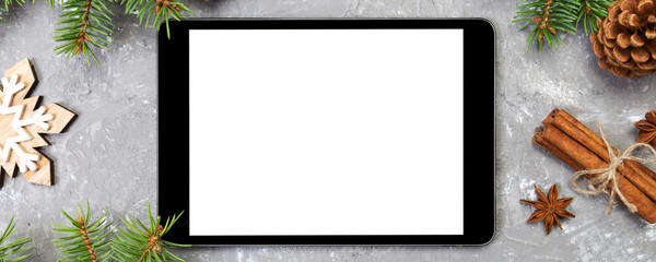 Wall Mural - Digital tablet mock up with rustic Christmas gray cement background decorations for app presentation. top view with copy space