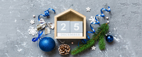 Wall Mural - Christmas calendar 25 december. Christmas gift, fir branches, pine cones. Flat lay, top view. New Year decorations on a colored background