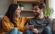 © li - Indian happy mature woman lady with young man male sitting on cozy sofa couch talk gossip share story indoor home adult mom teen son boy speak funny joke enjoy day spend time have fun joy inside house