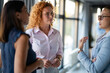 © Zoran Jesic - Businesswomen having serious discussion in modern office hallway