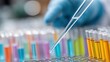 © AUAChanel - Close Up of a Scientist Using a Pipette to Add Liquid to Colorful Test Tubes in a Laboratory