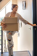 © puhimec - Young woman with boxes opening door in hallway. Online shopping.