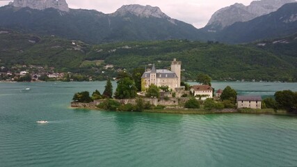 Wall Mural - Château de Duingt, a stunning castle on Lake Annecy, France. Footage starts towards the amazing building and then fly over it and rotates to the left revealing the surrounding views of the lake.