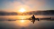 © yevhen89 - Lone rower in a single scull glides across a calm, misty lake during a breathtaking golden sunrise