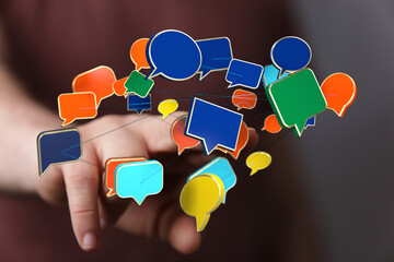 Wall Mural - Conceptual image showcasing digital communication and connection through the interaction of speech bubbles and a hand, representing modern techn