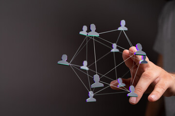 Wall Mural - Abstract image of a network concept. A hand touches a digital connection symbol, a graphic with people icons. Shows communication, teamwork, com