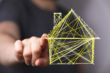 Wall Mural - Abstract digital home concept. A hand pointing at a house made of lines. Futuristic representation of technology and real estate.