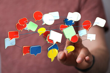 Wall Mural - Conceptual image showing a hand interacting with connected speech bubbles, symbolizing communication, networking, and social media interactions.