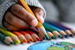 © irina - Colorful pencils arranged with a child's hand drawing on paper during a creative afternoon session