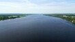 © mediawhalelicensing  - Wide river flows through green landscape under blue sky. Clip
